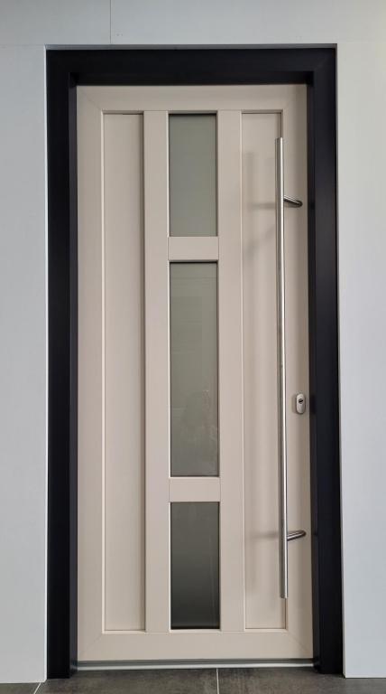 <p>Donkere deurpost met witte deur met raam.</p>